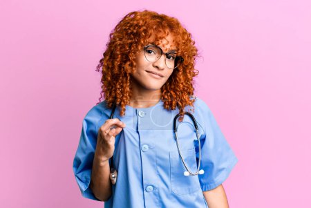 Téléchargez les photos : Cheveux roux jolie femme à l'air arrogant, réussi, positif et fier. concept d'infirmière - en image libre de droit