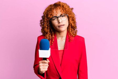 Téléchargez les photos : Cheveux roux jolie femme se sentant perplexe et confus. concept de journaliste et présentateur - en image libre de droit