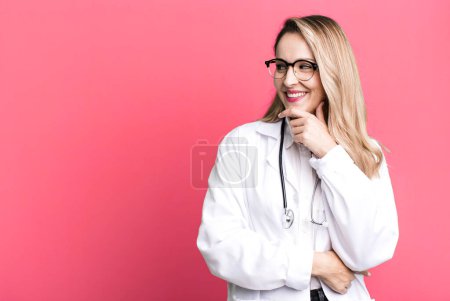 Téléchargez les photos : Smiling with a happy, confident expression with hand on chin. medicine student or physician - en image libre de droit