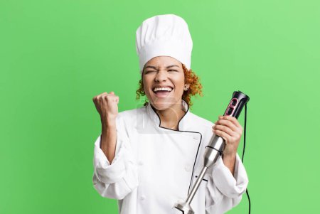 Photo for Red hair pretty chef woman with a hand mixer - Royalty Free Image