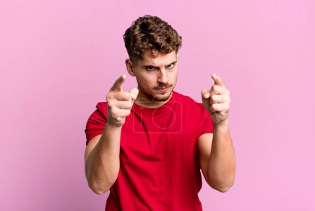 Téléchargez les photos : Young adult caucasian man pointing forward at camera with both fingers and angry expression, telling you to do your duty - en image libre de droit