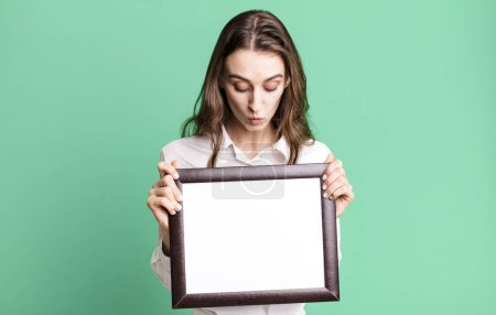 Foto de Joven bonita mujer sosteniendo un espacio de copia marco vacío - Imagen libre de derechos