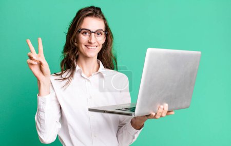 Téléchargez les photos : Jeune jolie femme d'affaires avec un ordinateur portable - en image libre de droit