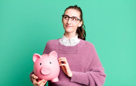 Photo for Young pretty woman with a piggy bank - Royalty Free Image
