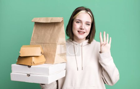 Photo for Young pretty woman smiling and looking friendly, showing number four. take away fast food concept - Royalty Free Image