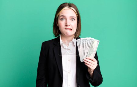 Téléchargez les photos : Young pretty woman looking puzzled and confused. dollar banknotes - en image libre de droit