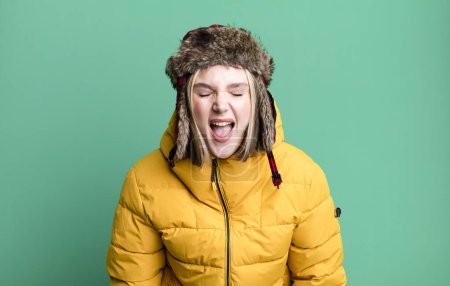 Photo for Young pretty woman shouting aggressively, looking very angry. cold and coat concept - Royalty Free Image