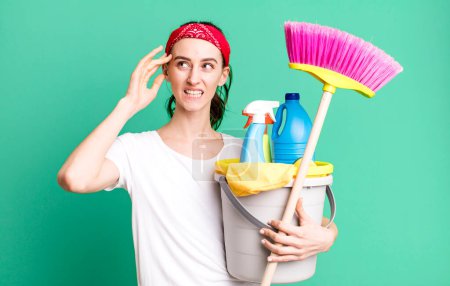 Téléchargez les photos : Young pretty woman feeling confused and puzzled, showing you are insane. housekeeper concept - en image libre de droit