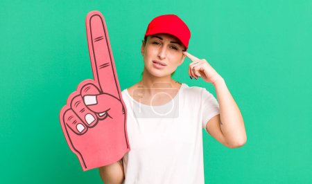 Photo for Young pretty woman feeling confused and puzzled, showing you are insane. number one fan concept - Royalty Free Image