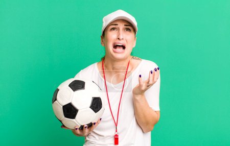 Photo for Young pretty woman looking desperate, frustrated and stressed. soccer coach concept - Royalty Free Image