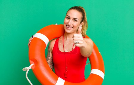 Photo for Young pretty woman feeling proud,smiling positively with thumbs up. summer and lifeguard concept - Royalty Free Image
