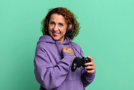 Photo for Pretty middle age woman feeling happy and facing a challenge or celebrating playing virtual game. gamer concept - Royalty Free Image