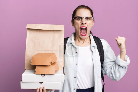 Foto de Una mujer bastante hispana gritando agresivamente con una expresión furiosa. entrega comida rápida take away concepto - Imagen libre de derechos