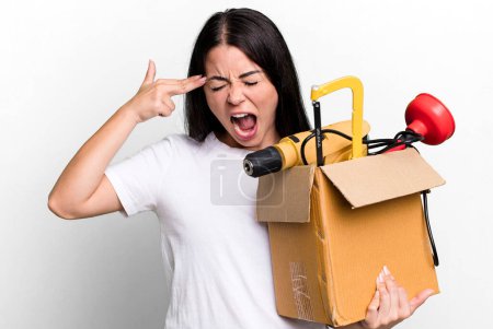 Photo for Hispanic pretty woman looking unhappy and stressed, suicide gesture making gun sign with a tool box - Royalty Free Image