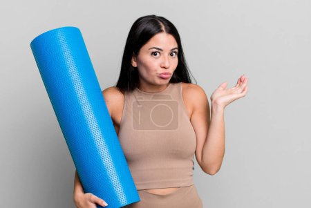 Photo for Hispanic pretty woman feeling puzzled and confused and doubting yoga concept - Royalty Free Image