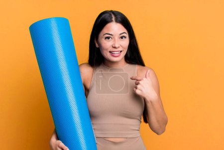 Téléchargez les photos : Hispanic pretty woman feeling happy and pointing to self with an excited yoga concept - en image libre de droit