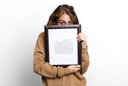 Foto de Hispanic pretty young woman with a blank frame copy space - Imagen libre de derechos