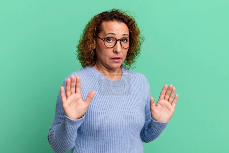 Photo for Middle age hispanic woman looking nervous, anxious and concerned, saying not my fault or I didnt do it - Royalty Free Image