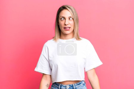 Téléchargez les photos : Blonde femme adulte regardant fou et drôle avec une expression stupide aux yeux croisés, plaisanter et tromper autour - en image libre de droit