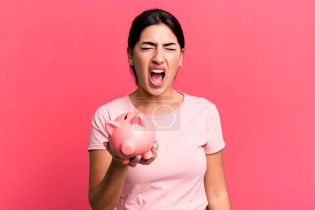 Photo for Shouting aggressively, looking very angry. with a piggy bank - Royalty Free Image