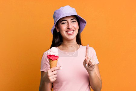Foto de Sonriendo y luciendo amigable, mostrando el número uno. helados y concepto de verano - Imagen libre de derechos