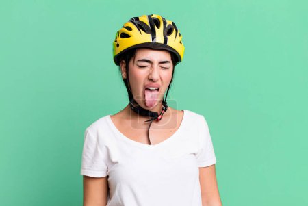 Foto de With cheerful and rebellious attitude, joking and sticking tongue out. bike helmet concept - Imagen libre de derechos