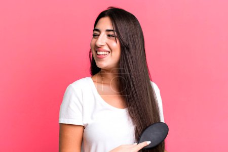 Téléchargez les photos : Pretty hispanic woman using a hair comb - en image libre de droit