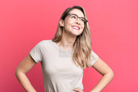 Photo for Looking happy, cheerful and confident, smiling proudly and looking to side with both hands on hips - Royalty Free Image