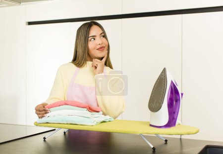 Téléchargez les photos : Pretty latin woman housekeeper. iron clothes concept - en image libre de droit