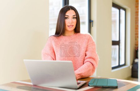 Téléchargez les photos : Pretty young woman with a laptop on a desk  at home - en image libre de droit