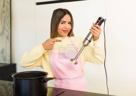 Téléchargez les photos : Jolie chef latino femme cuisine à la maison - en image libre de droit