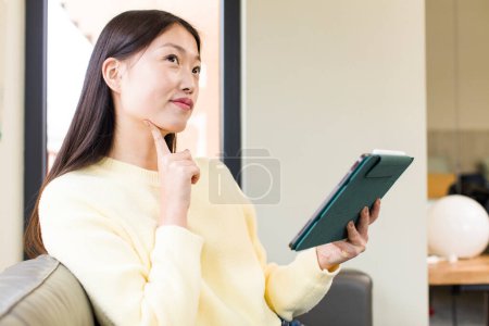 Photo for Asian pretty woman using a touchscreen pad - Royalty Free Image