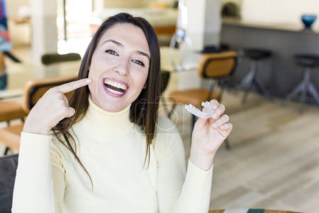 Téléchargez les photos : Adult pretty woman with a dentar retainer at home interior - en image libre de droit