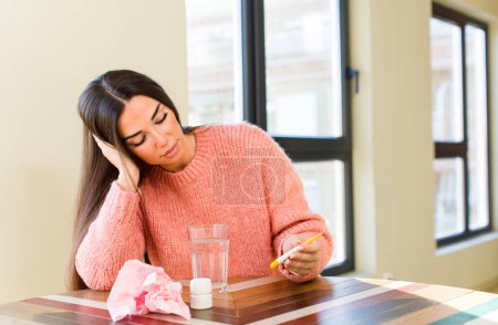 Foto de Joven mujer bonita con un vaso de agua y pastillas. concepto de gripe - Imagen libre de derechos