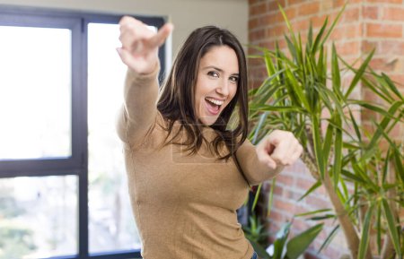 Photo for Young adult pretty woman feeling happy and confident, pointing to camera with both hands and laughing, choosing you - Royalty Free Image