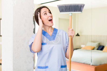Téléchargez les photos : Young pretty woman feeling happy, excited and surprised. housekeeper concept - en image libre de droit