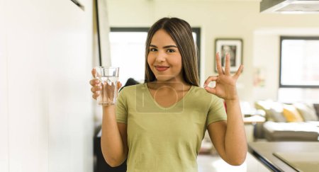 Téléchargez les photos : Pretty latin woman with a water glass at home - en image libre de droit