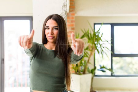 Photo for Young adult pretty woman pointing forward at camera with both fingers and angry expression, telling you to do your duty - Royalty Free Image