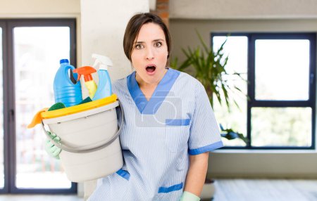 Photo for Young pretty woman looking very shocked or surprised. housekeeper concept - Royalty Free Image