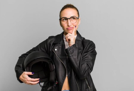 Téléchargez les photos : Young pretty woman with a motorbike helmet and a leather jacket - en image libre de droit