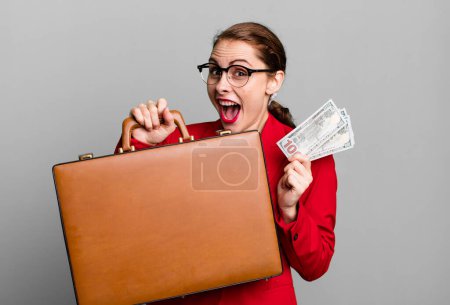 Photo for Young adult pretty businesswoman with a suitcase and bills - Royalty Free Image