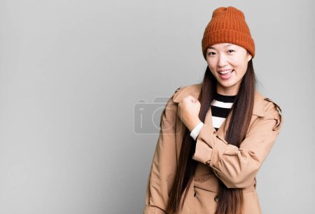 Photo for Pretty asian woman feeling happy and facing a challenge or celebrating - Royalty Free Image