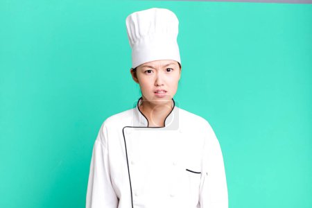 Photo for Pretty asian woman feeling puzzled and confused. restaurant chef concept - Royalty Free Image