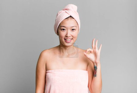 Téléchargez les photos : Pretty asian woman feeling happy, showing approval with okay gesture. beauty and shower concept - en image libre de droit