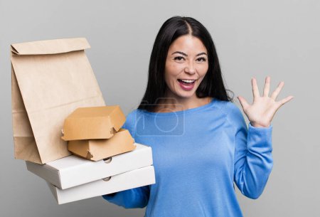Photo for Hispanic pretty woman feeling happy, surprised realizing a solution or idea. with take away fast food packages - Royalty Free Image