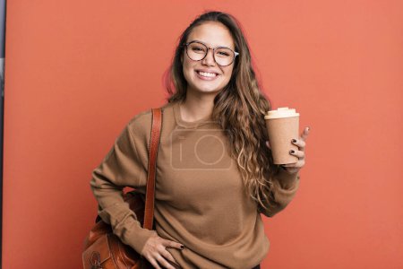 Téléchargez les photos : Hispanique jolie femme souriant joyeusement avec une main sur la hanche et confiant. concept de café à emporter - en image libre de droit