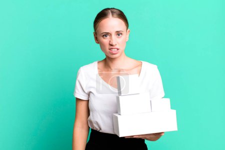 Téléchargez les photos : Caucasian pretty woman feeling puzzled and confused with white boxes packages - en image libre de droit