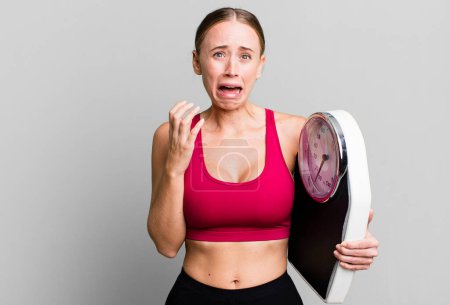 Photo for Caucasian pretty woman looking desperate, frustrated and stressed. fitness and diet concept - Royalty Free Image