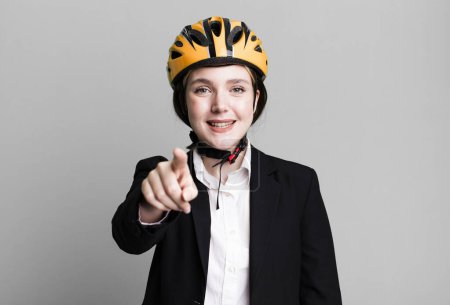 Photo for Young pretty woman pointing at camera choosing you. bike and businesswoman concept - Royalty Free Image