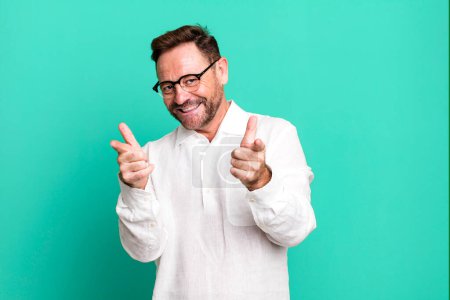 Photo for Smiling with a positive, successful, happy attitude pointing to the camera, making gun sign with hands - Royalty Free Image